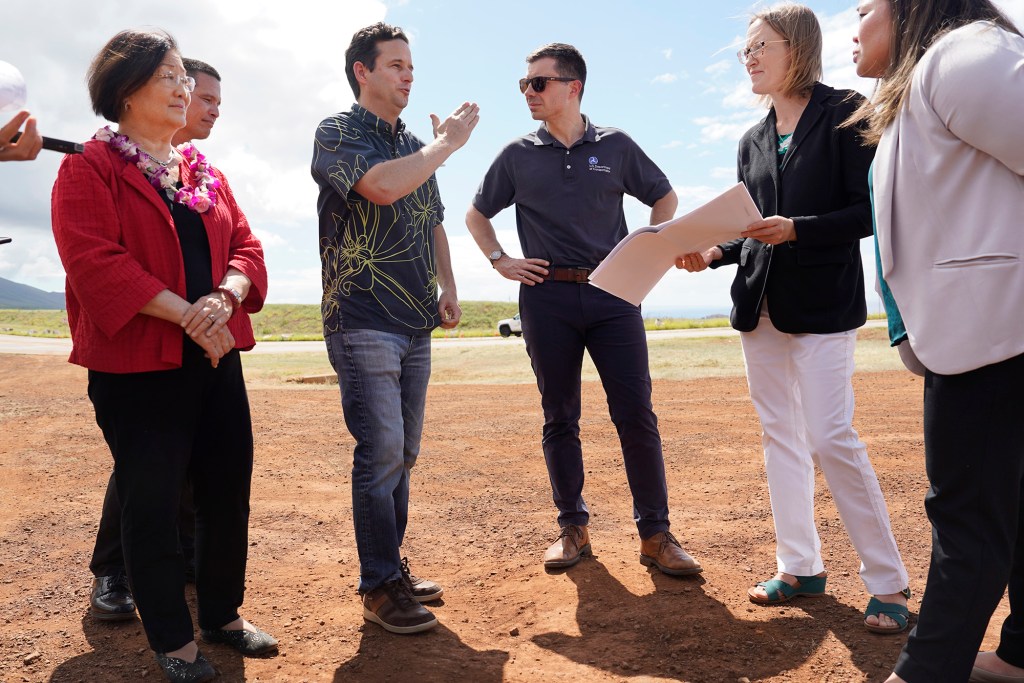 Transportation Secretary Pete Buttigieg, center right, listens to Sen. Brian Schatz along the Lahaina Bypass Wednesday, Feb. 21, 2024, in Lahaina. Senator Mazie Hirono, from left, Hawaii Department of Transportation director Ed Sniffen, Federal Highway Administration transportation engineer Lisa Powell and environmental engineer Meesa Otani listen in. (Kevin Fujii/Civil Beat/2024)
