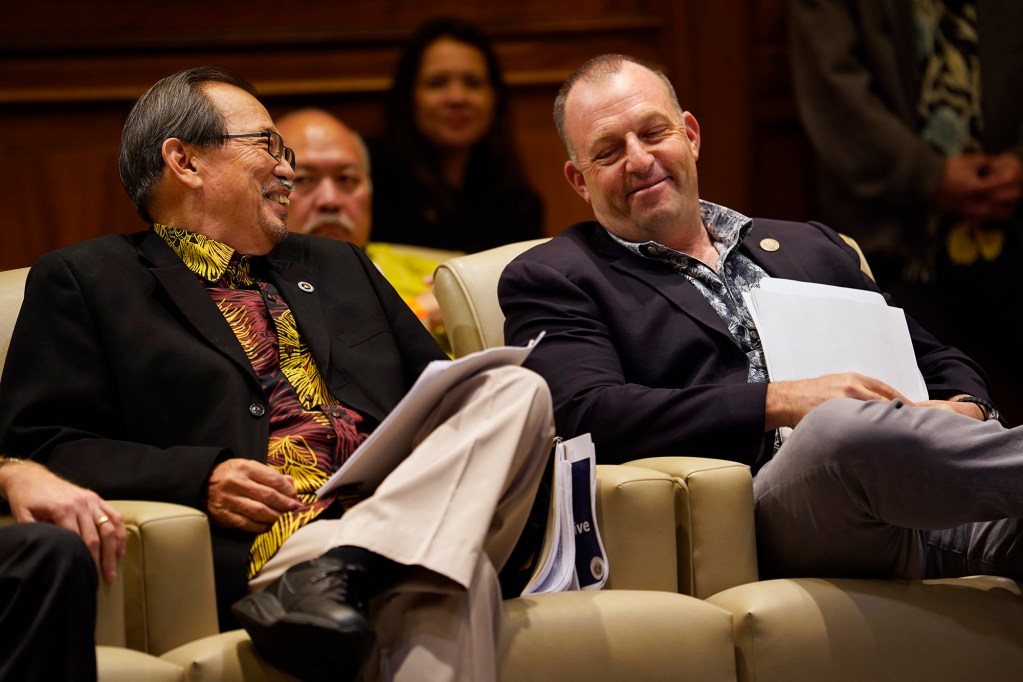 One Ohana Fund administrator retired Judge Ronald Ibarra, from left, and Gov. Josh Green share a light moment during a Tuesday, Feb. 27, 2024, press conference in Honolulu. The fund is designed to compensate loss of life and injury for those who survived the Aug. 8 fire on Maui. (Kevin Fujii/Civil Beat/2024)