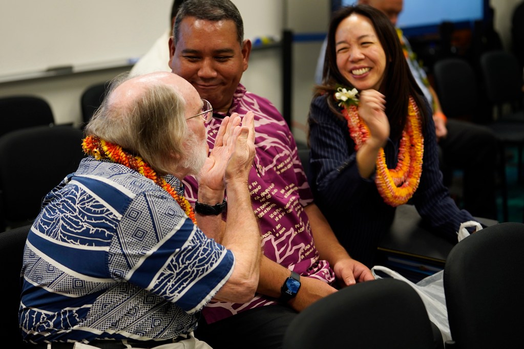 Former Gov. Neil Abercrombie, from left, playfully blows fellow University of Hawaii Board of Regents member Lauren Akitake a kiss after receiving a lei before their Senate committee on higher education committee confirmation hearing Tuesday, Feb. 27, 2024, in Honolulu. (Kevin Fujii/Civil Beat/2024)