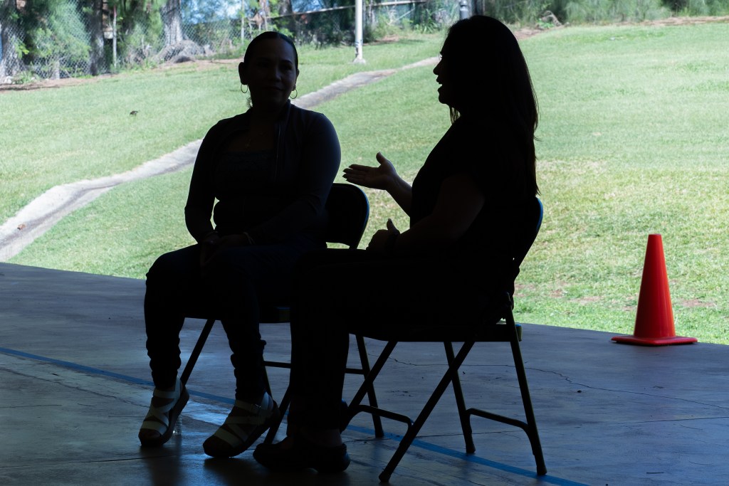 FEMA Interpreter Carolina Davis (brown top) meets with Spanish speaking immigrant Victoria Silva at Lahaina Civic Center, Friday March 1st, 2024. The two became aquainted when Victoria  sought assistance through FEMA following the devastating fires of August 8th. (David Croxford/Civil Beat/2024)