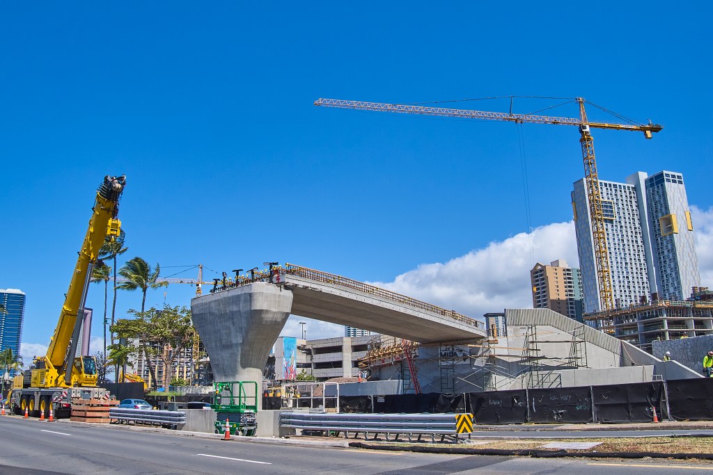 Construction continues on the $17.8 million elevated pedestrian walkway over Ala Moana Blvd. $14.3 million coming from the U.S. DOT's competitive Better Utilizing Investments to Leverage Development (BUILD) transportation discretionary grant program and the remainder from State Highway Funds. The project when completed will join the section of condominiums in Ward Village to Kewalos Basin where tour vessels are anchored in Kewalos Basin harbor and the very popular Ala Moana park, 100 acres of City and county maintained park area. (David Croxford/Civil Beat/2024)