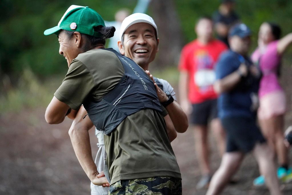 Takashi Yamada, from left, greets Takashi Okada before the Hawaiian Ultra Running Team kicks off their running season with the Aiea Loop Express at Keaīwa Heiau State Recreation Area Saturday, March 23, 2024, in Aiea. Runners consider this an easy course with a distance of only 6.75-mile and 1,442’ of elevation gain. The trail is mostly wide and free of challenging obstacles. (Kevin Fujii/Civil Beat/2024)