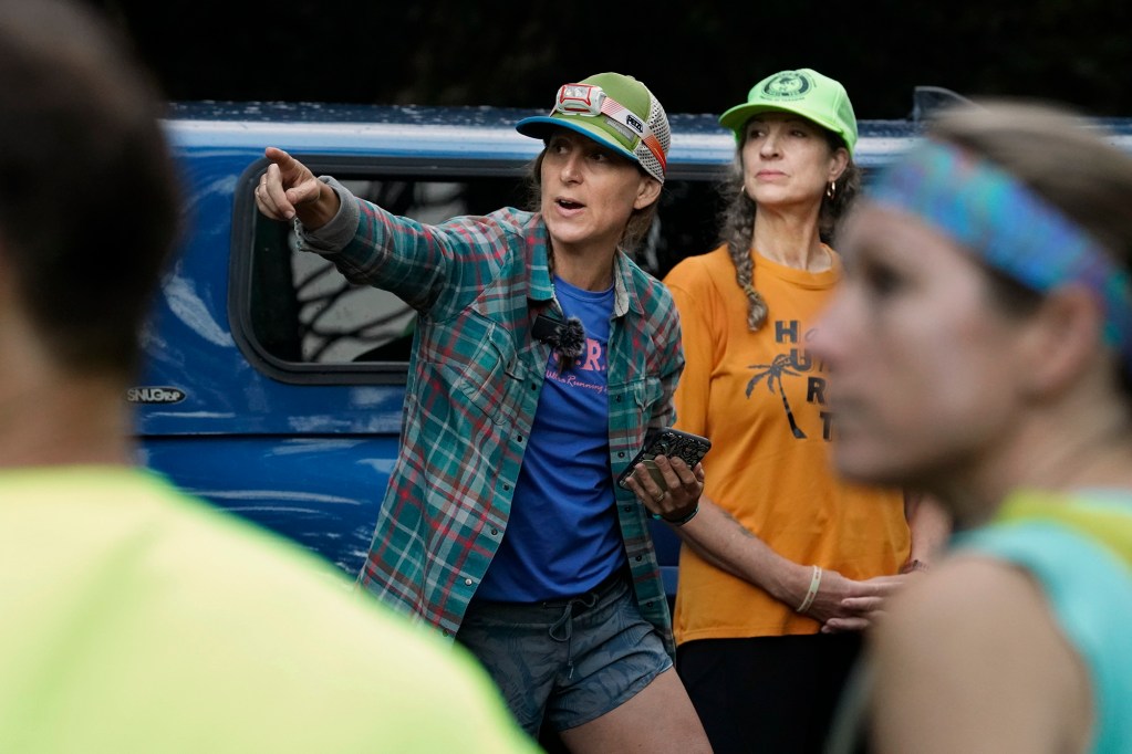 Hawaiian Ultra Running Team’s Shell Barbieri Lino points out the finish line as HURT secretary Jacki Doppelmayer looks on before kicking off their running season with the Aiea Loop Express at Keaīwa Heiau State Recreation Area Saturday, March 23, 2024, in Aiea. Runners consider this an easy course with a distance of only 6.75-mile and 1,442’ of elevation gain. The trail is mostly wide and free of challenging obstacles. (Kevin Fujii/Civil Beat/2024)
