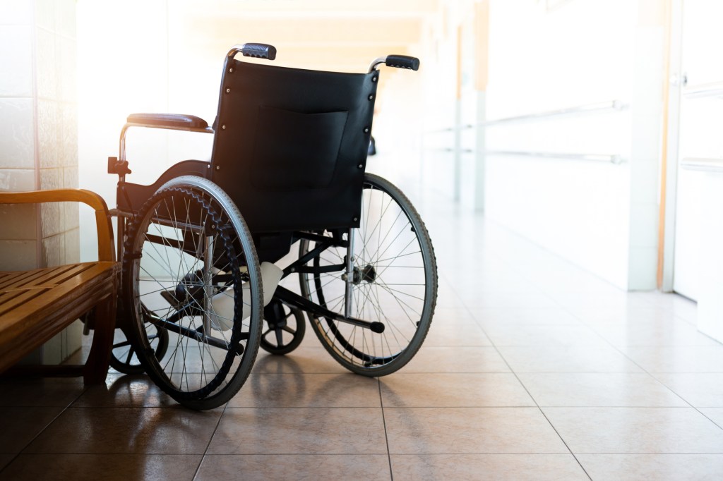File photo of a single wheelchair parked in hospital hallway.
