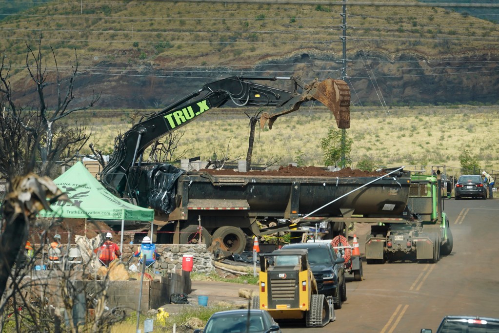 An excavator removes soil from a burned home Monday, April 8, 2024, in Lahaina. The West Maui town of Lahaina was destroyed in the Aug. 8, 2023, fire. (Kevin Fujii/Civil Beat/2024)