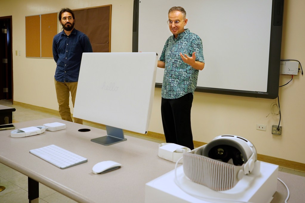 Kūlia Academy artificial intelligence/data science teacher Lutfi Sun, from left, and interim executive director Andy Gokce set up one of the charter school’s Apple Vision Pro headsets Wednesday, April 24, 2024, in Honolulu. This tuition-free charter school specializing in AI and data since only accepts 100 sixth graders. (Kevin Fujii/Civil Beat/2024)