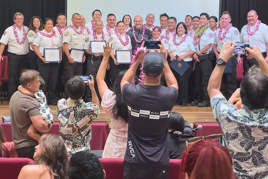 Proud parents and friends stand to photograph their promoted relatives following a first-of-its-kind promotion that took place 10 a.m. May 20 at Mission Memorial Auditorium to honor all current Honolulu Emergency Medical Service field operation supervisors (district chiefs) and unit supervisors. (David Croxford/Civil Beat/2024)