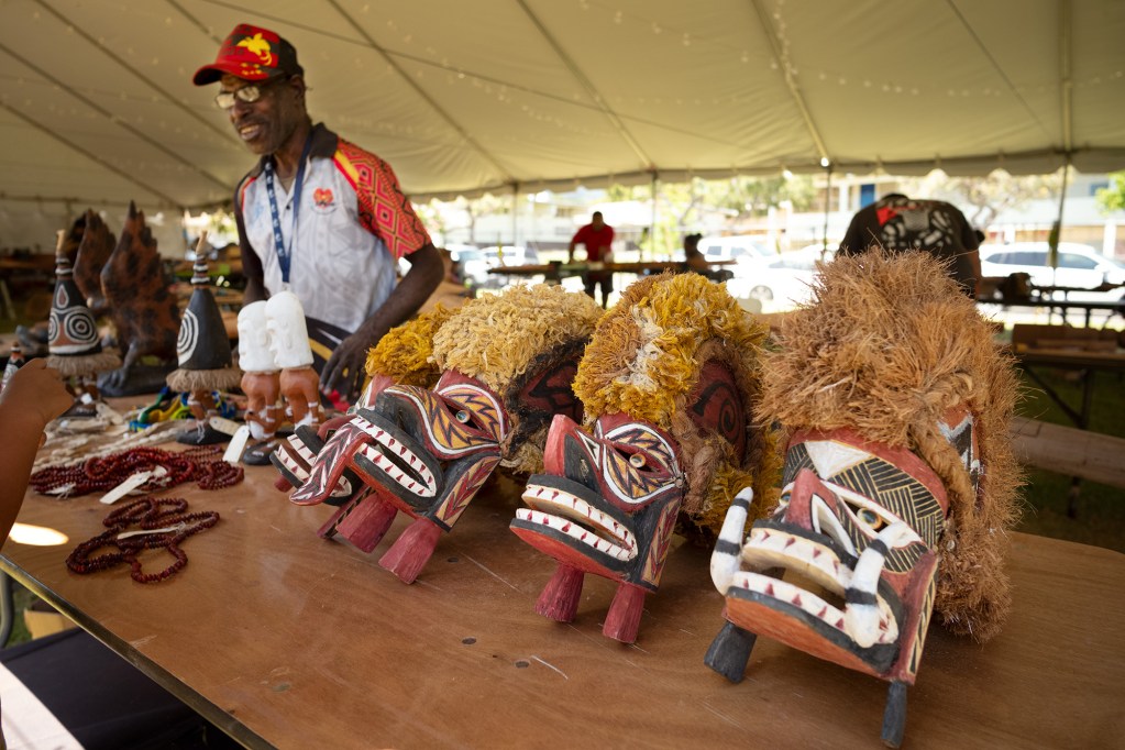 Papua New Guinea delegate Kauwi Jack shows off wood carvings at the Bishop Museum Sunday, June 8, 2024, in Honolulu. Jack is part of FestPac wood carvers at the Bishop Museum. (Kevin Fujii/Civil Beat/2024)