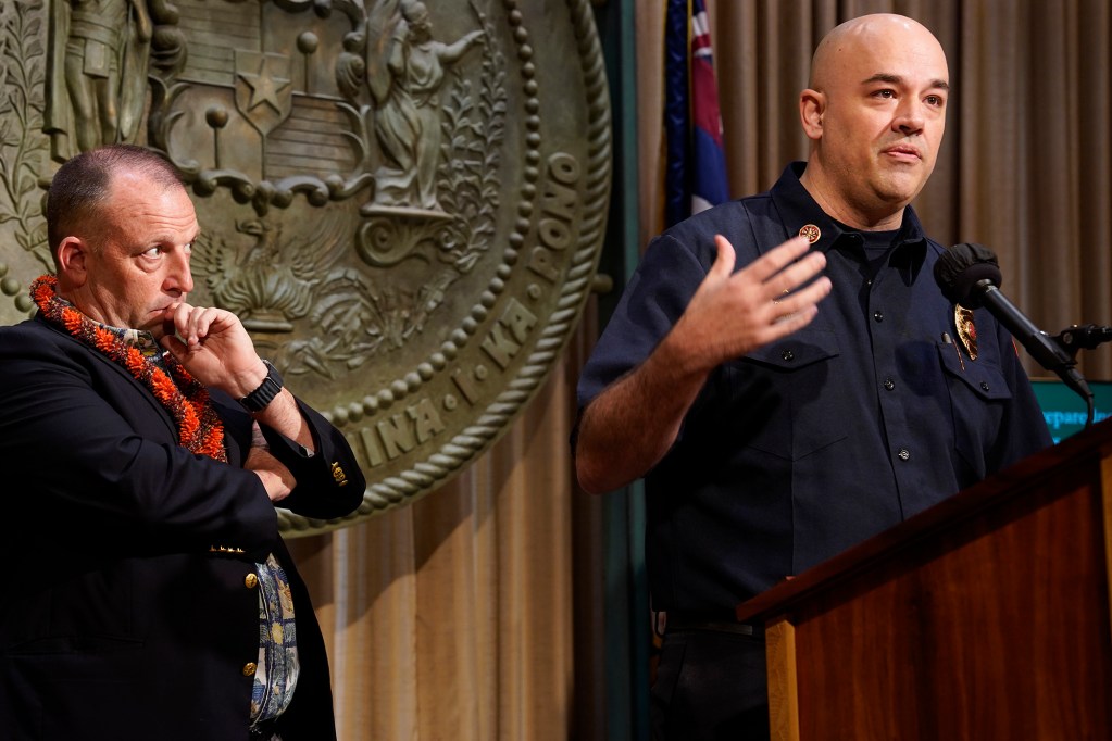 Gov. Josh Green listens to Hawaii County Fire Department Chief Kazuo Todd before signing new bills into law Friday, July 5, 2024, in Honolulu. The four bills stem from the Aug. 8 fire which destroyed Lahaina and Upcountry Maui. (Kevin Fujii/Civil Beat/2024)