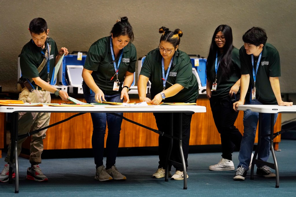 Office of Elections staffers prepare test ballots for official observers to practice with the vote counting system Saturday, July 27, 2024, in the Hawaii State Capitol Senate Chambers in Honolulu. (Kevin Fujii/Civil Beat/2024)
