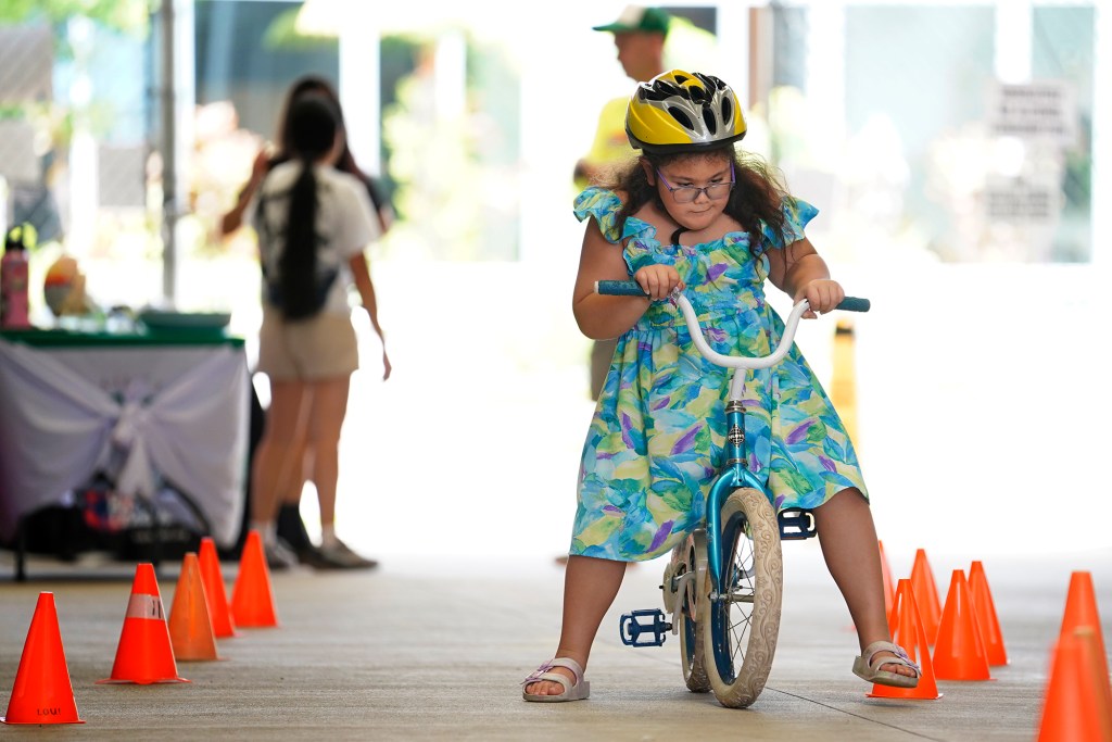 Jaselyn Dardeen, 7 of Ewa Beach, zooms around the race track as part of Hawaii Bicycle League Bike Month 2024, helmet giveaway Sunday, July 28, 2024, at SALT at Kakaako in Honolulu. (Kevin Fujii/Civil Beat/2024)