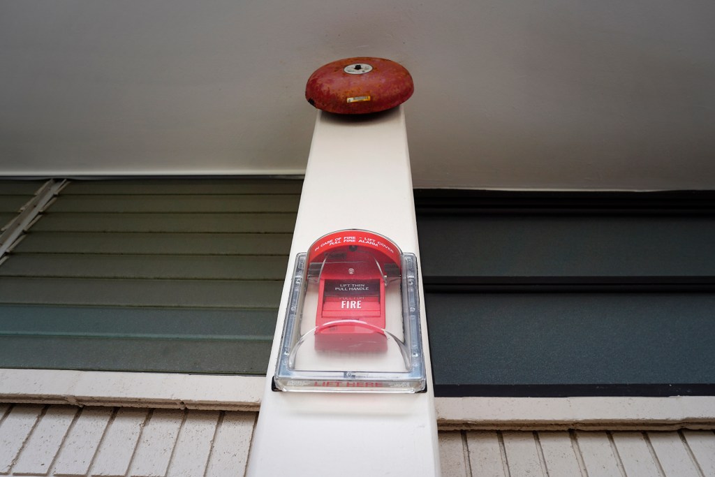 A fire alarm at Kahala Towers is photographed Monday, July 29, 2024, in Honolulu. Some residents are complaining about the financial burden put upon them as they’re being forced out of their units during the renovation. (Kevin Fujii/Civil Beat/2024)