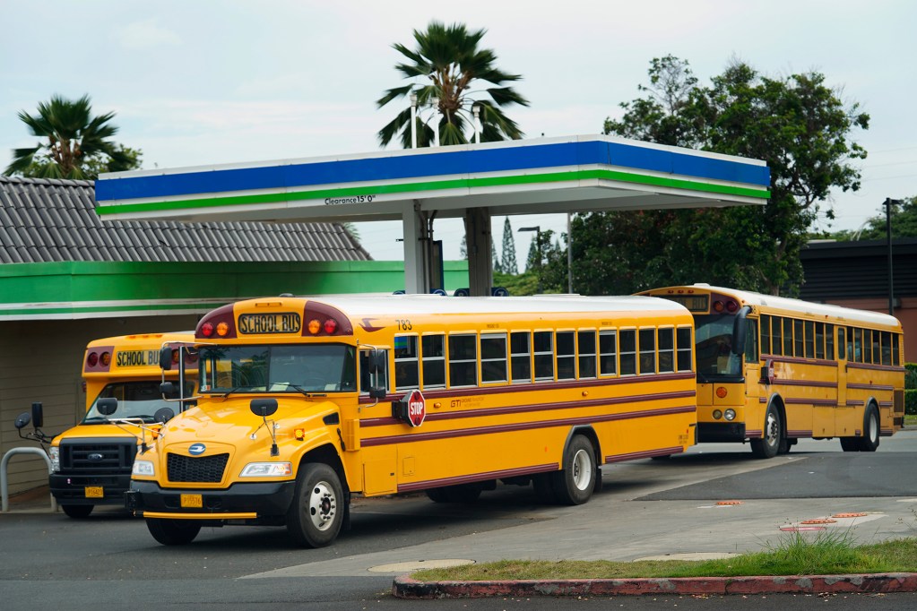 School buses fill up after their routes Monday, Aug. 26, 2024, in Waipahu. The Department of Education restarted numerous routes. Before the 2024-2025 school year began, parents were given three days notice some bus routes were no longer being offered. (Kevin Fujii/Civil Beat/2024)