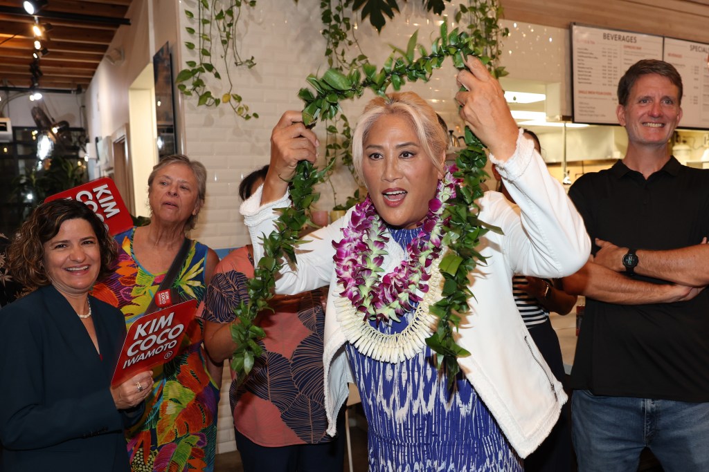 Hawaii House candidate Kim Coco Iwamoto anticipates the first printout of the Democratic Party primary election at a coffee shop in Kakaako on Saturday. (Marco Garcia/Civil Beat/2024)