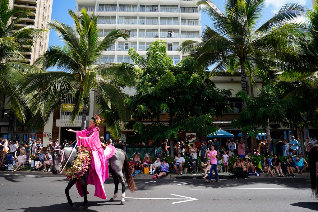 Crowds along Kalakaua Avenue and on building balconies watch a pau rider during the Aloha Festivals 76th Annual Floral Parade Saturday, Sept. 25, 2024, in Honolulu. (Kevin Fujii/Civil Beat/2024)