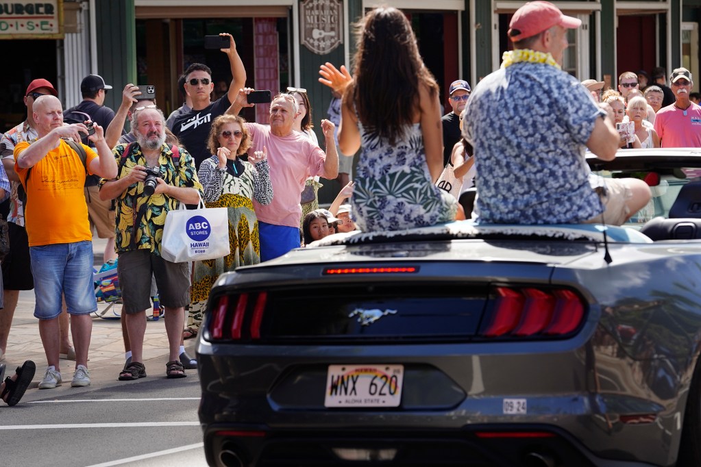 Gov. Josh Green and his daughter Maia wave to the crowd along Kalakaua Avenue during the Aloha Festivals 76th Annual Floral Parade marches down Saturday, Sept. 25, 2024, in Honolulu. (Kevin Fujii/Civil Beat/2024)