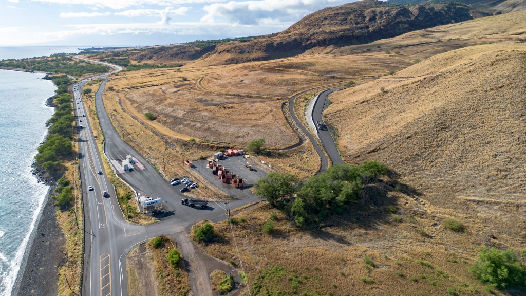 An aerial view shows a truck leaving the Olowalu temporary landfill site after dumping debris from the Lahaina fire on Sunday, July 7, 2024, in Lahaina, Hawaii. (AP Photo/Mengshin Lin)