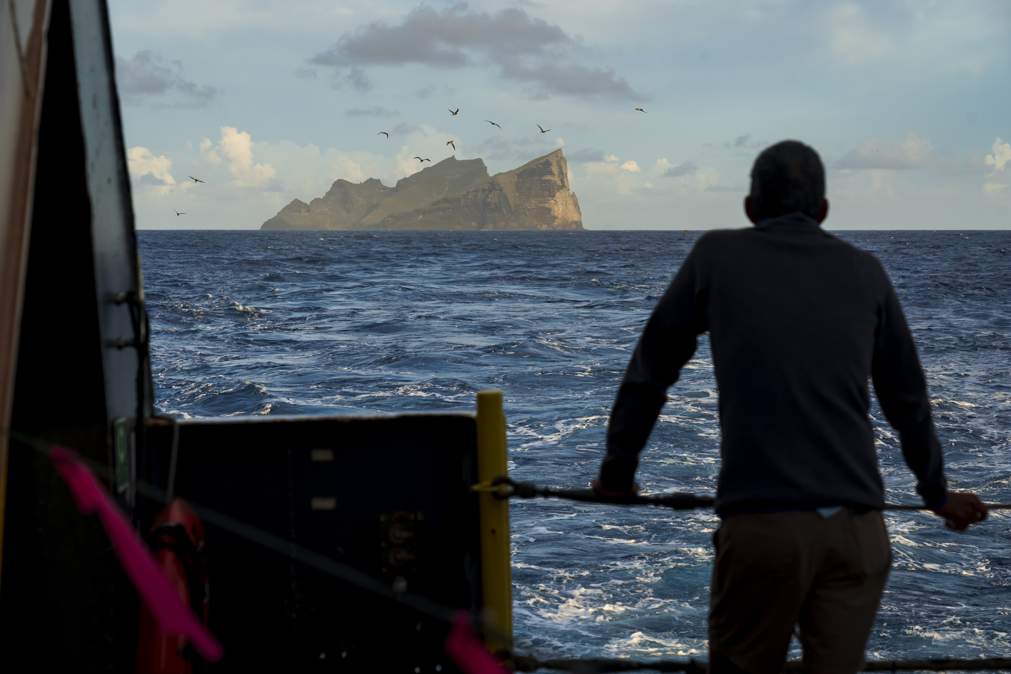 Randy Kosaki, NOAA's chief scientist aboard the Oscar Elton Sette research vessel, looks out at Nihoa as the ship cruised through Papahanaumokuakea Marine National Monument in the Northwestern Hawaiian Islands. (Nathan Eagle/Civil Beat/2024)