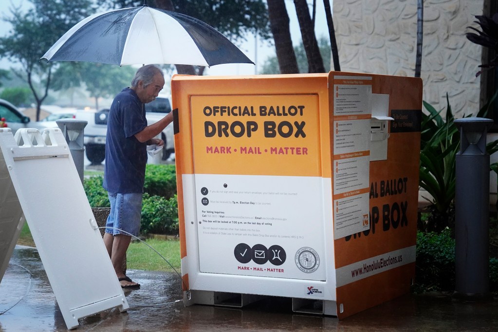 A voter avoids the wait to vote in person and drops his ballot in the Official Ballot Drop Box at Kapolei Hale Tuesday, Nov. 5, 2024, in Kapolei. Elections administrator for the City and County of Honolulu Rex Quidilla says it’s been a long time since it rained on Election Day. (Kevin Fujii/Civil Beat/2024)