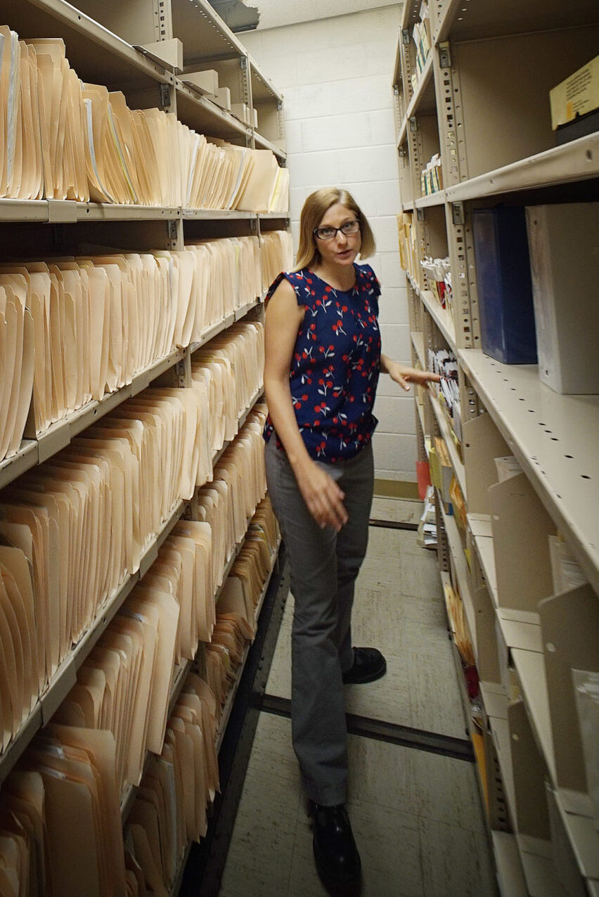 Medical Examiner Investigator Charlotte Carter walks past a portion of area on the 2nd floor records area of the building with leaky roof and stains.