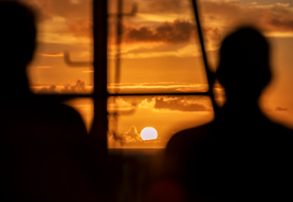 Randy Kosaki, NOAA’s chief scientist aboard the Oscar Elton Sette research vessel, watched the sun set with other marine scientists as the ship cruised through Papahanaumokuakea Marine National Monument in the Northwestern Hawaiian Islands. (Nathan Eagle/Civil Beat/2024)