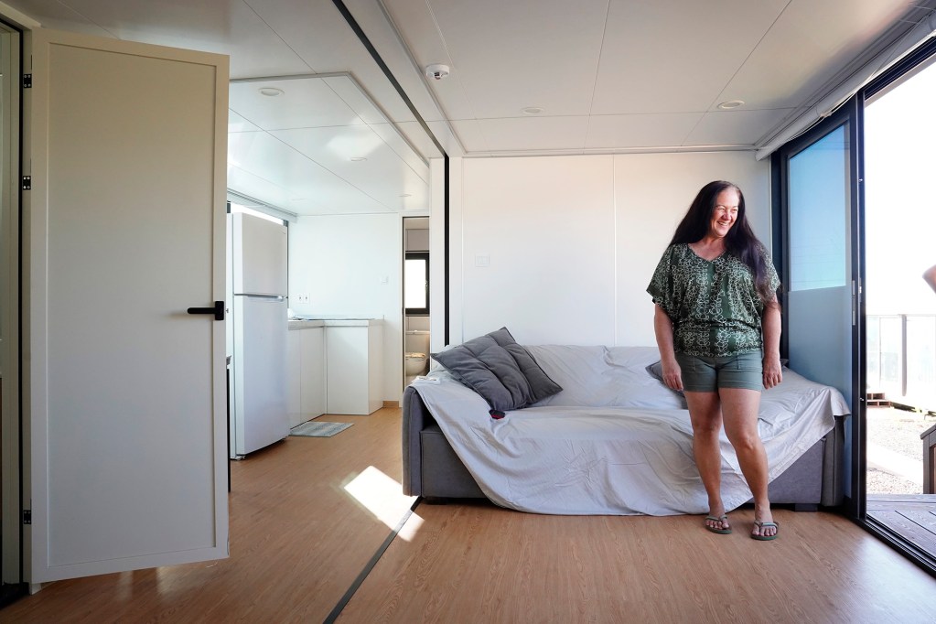 Lana Vierra smiles as Ka La‘i Ola employees check on her move-in progress Thursday, Dec. 19, 2024, in Lahaina. “I’m so happy.” Vierra said, “I love it!” (Kevin Fujii/Civil Beat/2024)