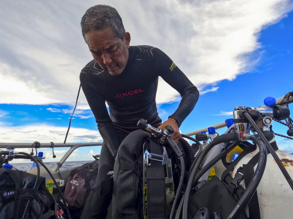 Randy Kosaki, deputy superintendent for NOAA of Papahānaumokuākea Marine National Monument, grabs his scuba gear for a dive in the Northwestern Hawaiian Islands. (Nathan Eagle/Civil Beat/2024)