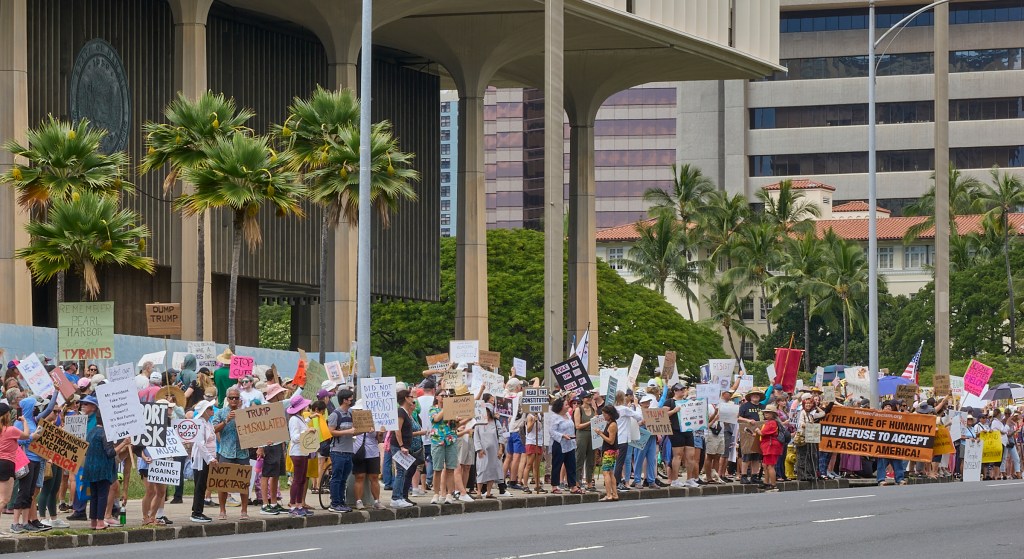 While most of Hawaii celebrated President’s Day 2025 spending time with their families, a vocally confrontational crowd crooned their opposition to President Trump’s attempts, with the help of Elon Musk, to follow through on President Obama’s Executive Order 13576 signed on June 13th 2011 whose thrust was to deliver an Efficient, Effective, and Accountable Government.
(David Croxford/Civil Beat/2025)