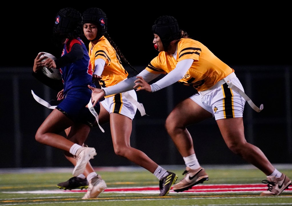 Nanakuli’s Carlee Sausi-Callejo, right #25, and Zoe Unga, middle #15, de-flag Wai’anae’s Kawena-Lynn Kaluna, left #15, during their first Hawai’i high school girl’s flag football game Tuesday, March 25, 2025, at Raymond Torii Field in Wai’anae. (Kevin Fujii/Civil Beat/2025)