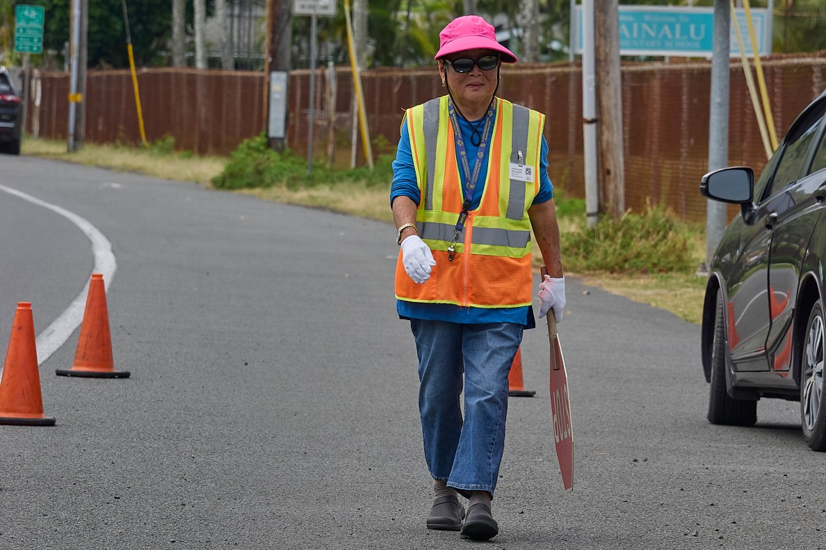 Elsie Miyashiro guards the intersection of 662 N. Kainalu Drive and Kaha Streets in Kailua. ItÕs a small but busy intersection behind Kainalu Elementary school.  Miyashiro was photographed on Thursday April 3rd during her afternoon shift. (David Croxford/Civil Beat/2025)
