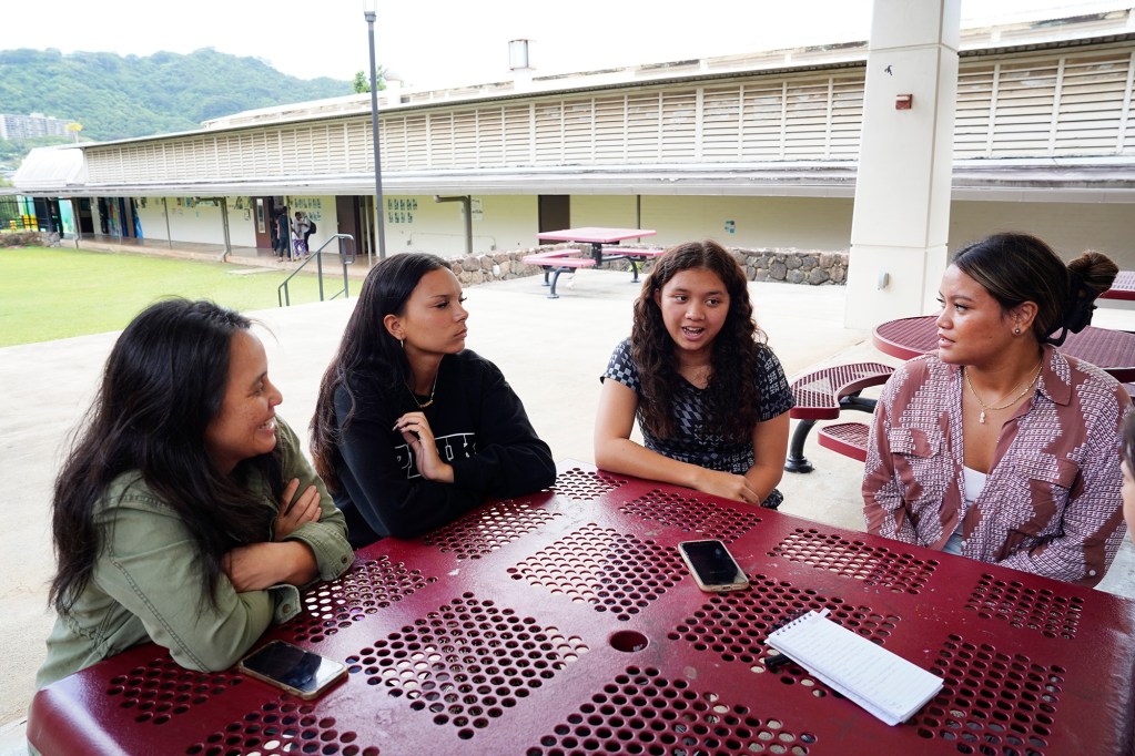 Castle High School students talk about food and school lunches Monday, May 5, 2025, in Kāneʻohe. They are teacher Lauren Pokipala, from left, and juniors Keira Torres, Tayli Kahoopii and Hallia Tom-Jardine. (Kevin Fujii/Civil Beat/2025)