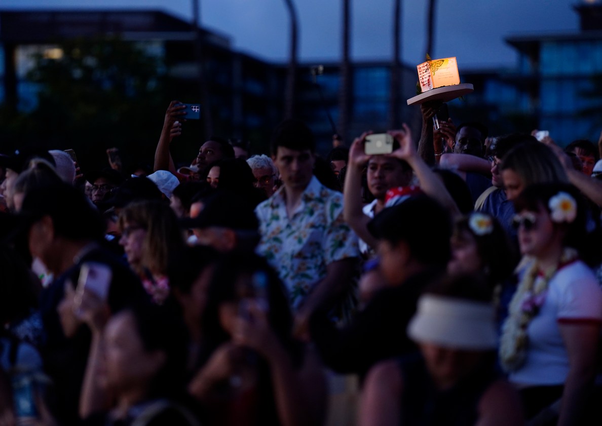 A lantern is held above the crowd to reach the water during the 27th Annual Shinnyo Lantern Floating Hawaiʻi Monday, May 26, 2025, at Ala Moana Regional Park in Honolulu. 6,000 lanterns with messages to lost loved ones are launched by family members. (Kevin Fujii/Civil Beat/2025)