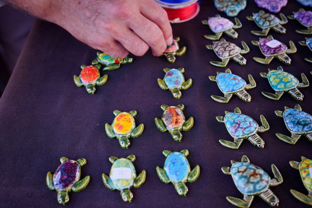 “Big Island Brian” Longerbeam, of Kurtistown, aligns his fired-ceramics honu display at the Hilo Farmer’s Market Saturday, May 31, 2025, in Hilo. (Kevin Fujii/Civil Beat/2025)