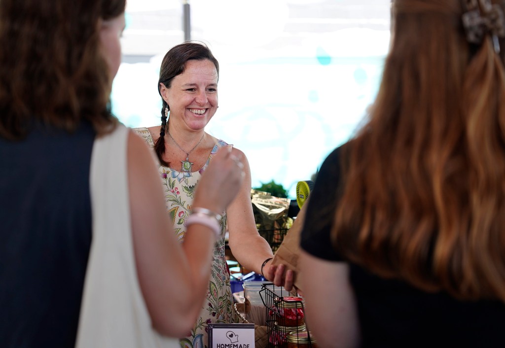 Lehua Fudge’s Carmen Cosby hands out samples of her sweets at the Hilo Farmer’s Market Saturday, May 31, 2025, in Hilo. (Kevin Fujii/Civil Beat/2025)
