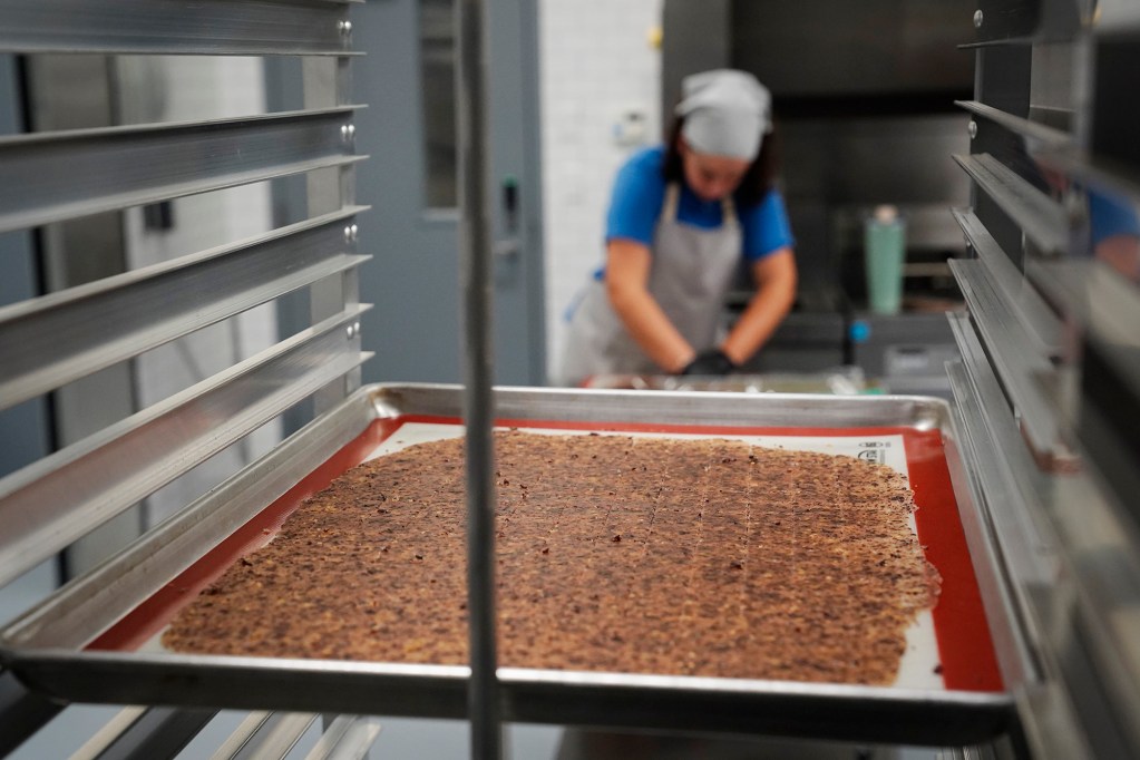 Jina Wye’s assistant Grace Gregg cuts limu-cracker batter at the Wahiawā Value-Added Product Development Center Wednesday, Sept. 17, 2025, in Wahiawā. The center makes producing her “Made in Hawaiʻi” crackers easier with facilities and amenities usually owned by mass-production companies. (Kevin Fujii/Civil Beat/2025)