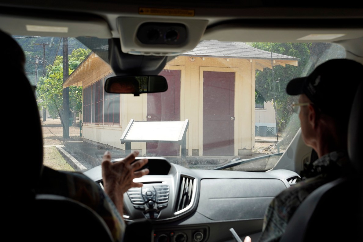 Kalaupapa Saints Tour guide John Meadows, from left, and Randy King, founder and CEO of Seawind Tours & Travel approach the Longhouse Thursday, Sept. 18, 2025, in Kalaupapa. Patients and visitors met here, separated by a screen. (Kevin Fujii/Civil Beat/2025)