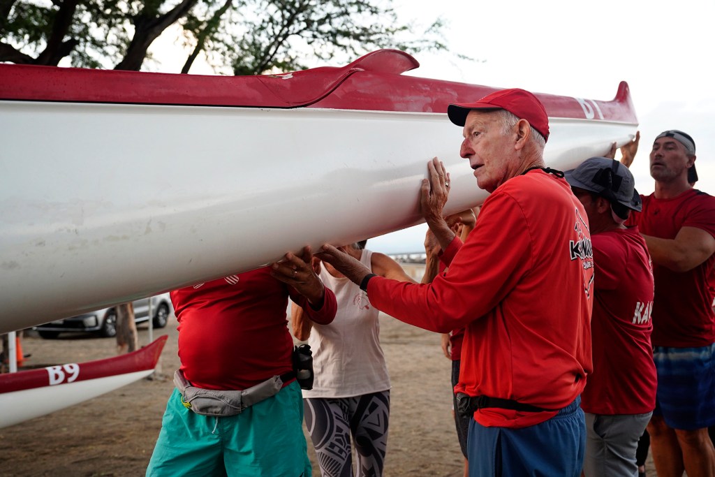 George Fry and crew lift a canoe before a Kawaihae Canoe Club workout Friday, Oct. 3, 2025, in Waimea. (Kevin Fujii/Civil Beat/2025)