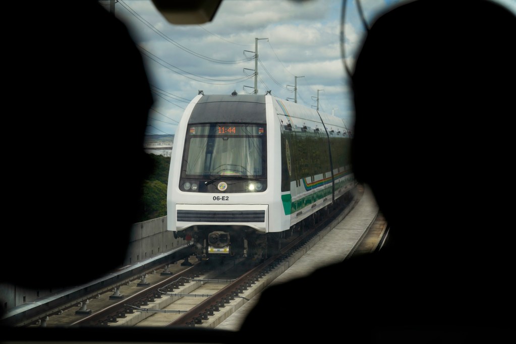 Photographers watch a Skyline commuter train depart from  Āhua - Lagoon Drive station Thursday, Oct. 9, 2025, in Honolulu. (Kevin Fujii/Civil Beat/2025)