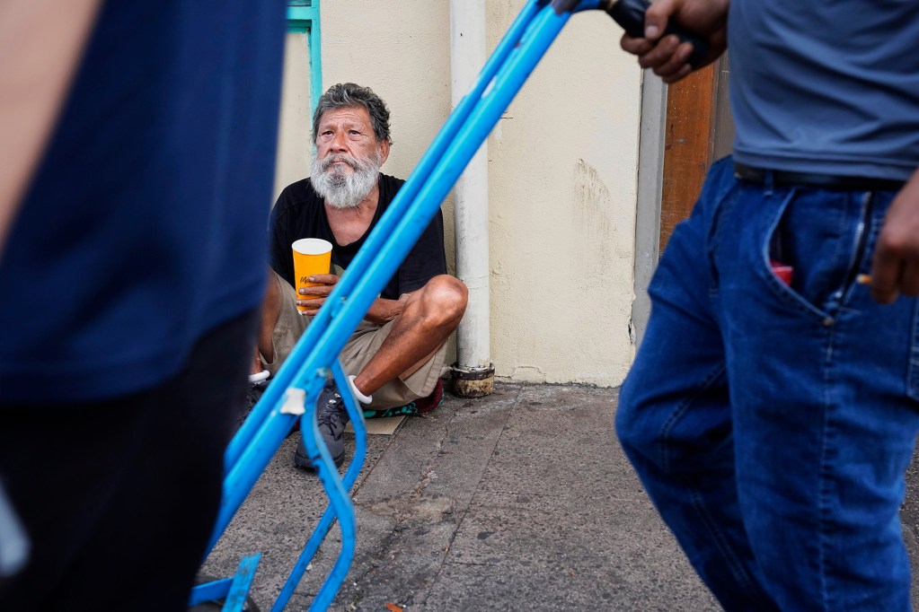 Tristan Martinez watches passsers-by Friday, Oct. 16, 2025, in Honolulu’s Chinatown. Martinez is homeless and stays on the streets in Chinatown. (Kevin Fujii/Civil Beat/2025)
