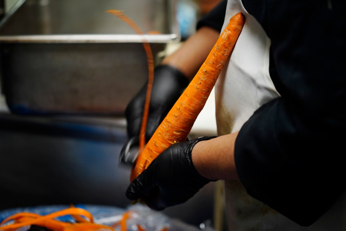 Hilton Hawaiian Village kitchen cook peels carrots Tuesday, Nov. 25, 2025, in Honolulu. (Kevin Fujii/Civil Beat/2025)
