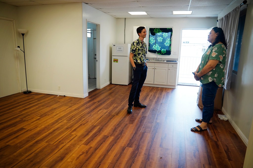 Family Promise of Hawaiʻi, Executive Director Ryan Catalani, left, chats with Case Worker Fita Nisa Wednesday, Dec. 17, 2025, in Honolulu. Changes to federal policy are threatening tens of millions of dollars in local funding for homelessness programs and service providers. Family Promise of Hawaiʻi provides services and housing to homeless families. Catalani thinks it could be an opportunity to develop more innovative programs and responses to homelessness if they have to turn to local funding sources. (Kevin Fujii/Civil Beat/2025)