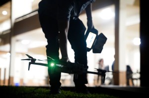 A drone pilot picks up his craft before Department of Law Enforcement Director Mike Lambert takes journalists on a ride along Wednesday, Dec. 31, 2025, in Waipahu. New laws, the use of aerial drones and citizens heeding the dangers of fireworks noticeably  curbed the annual personal pyrotechnics. (Kevin Fujii/Civil Beat/2025)
