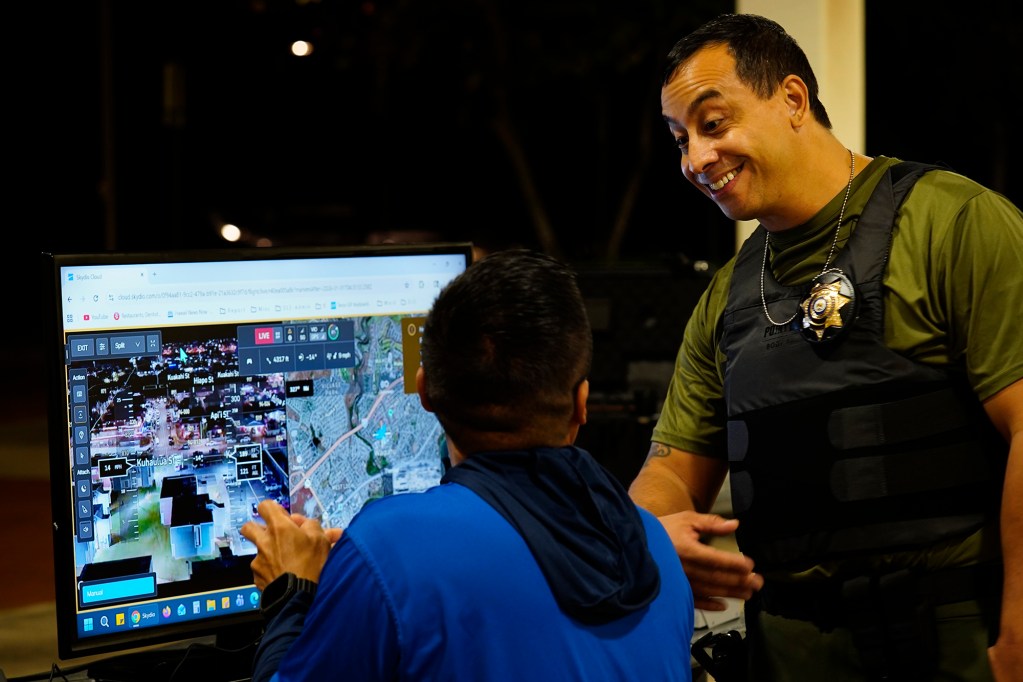 Department of Law Enforcement Director Mike Lambert talks with a drone pilot before taking journalists on a ride along Wednesday, Dec. 31, 2025, in Waipahu. New laws, the use of aerial drones and citizens heeding the dangers of fireworks noticeably  curbed the annual personal pyrotechnics. (Kevin Fujii/Civil Beat/2025)