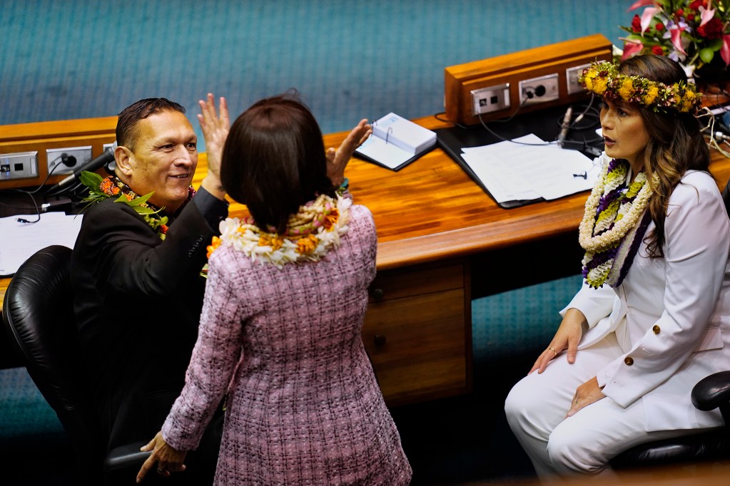 Sens. Kurt Fevella, from left, high fives Donna Kim as Samantha DeCorte looks on before the Hawaiʻi State Legislature opens Wednesday, Jan. 21, 2026, in Honolulu. (Kevin Fujii/Civil Beat/2026)