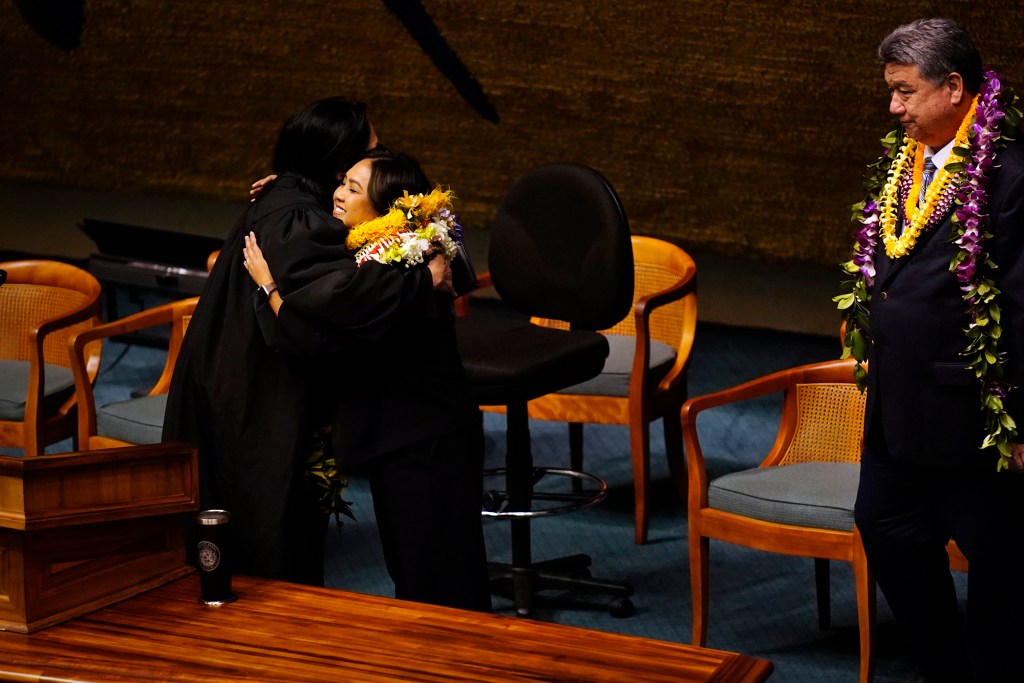 Acting Chief Justice of the Hawaiʻi Supreme Court Sabrina McKenna hugs Sen. Rachele Lamosao after swearing her in during the opening of the Hawaiʻi State Legislature Wednesday, Jan. 21, 2026, in Honolulu. Senate President Ron Kouchi looks on. Gov. Josh Green appointed Lamosao on Dec. 3, 2025. (Kevin Fujii/Civil Beat/2026)