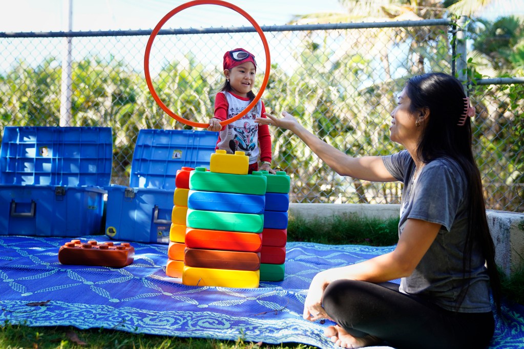 Hulili Borges, 4, shares a hoop with her mother Ghia Borges at Keiki O Ka ʻĀina Tuesday, Jan. 27, 2026, in Hauʻula. Federal funding cuts for Native Hawaiian education programs will significantly impact family-child interaction learning programs (FCILs) serving kids ages 0 to 5. The programs primarily target rural and Native Hawaiian communities who have limited early education/childcare options. The expected federal cuts will reduce the number of FCIL programs from 60 to 3. (Kevin Fujii/Civil Beat/2026)