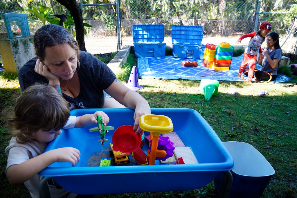 Finn Dillen, 2 1/2, plays with water toys with his mother Jessica Dillen at Keiki O Ka ʻĀina class Tuesday, Jan. 27, 2026, in Hauʻula. Federal funding cuts for Native Hawaiian education programs will significantly impact family-child interaction learning programs (FCILs) serving kids ages 0 to 5. The programs primarily target rural and Native Hawaiian communities who have limited early education/childcare options. The expected federal cuts will reduce the number of FCIL programs from 60 to 3. (Kevin Fujii/Civil Beat/2026)