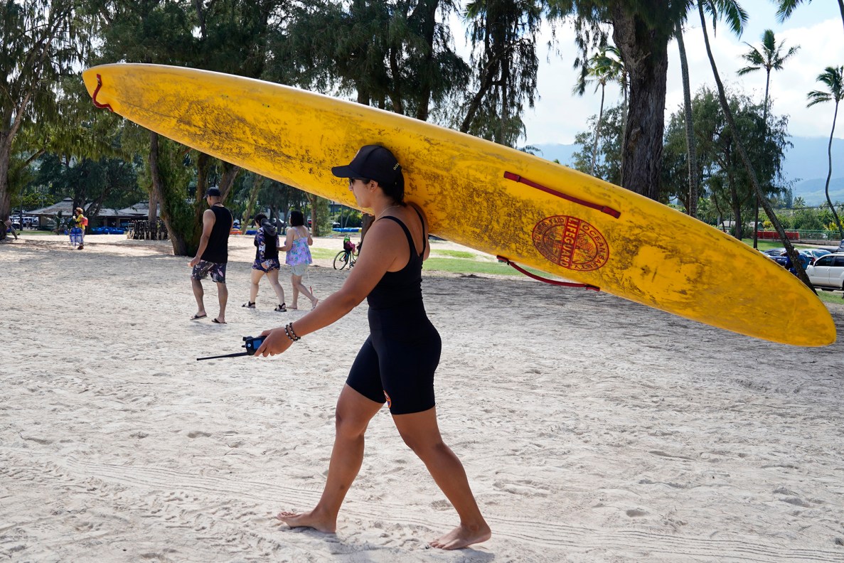 Honolulu Ocean Safety Departmen Lt. Chelsea Kahalepauole-Bizik shoulders a rescue board at Kailua Beach Park Tuesday, Jan. 27, 2026, in Kailua. (Kevin Fujii/Civil Beat/2026)