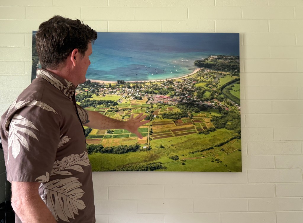 Joel Guy of the Hanalei Initiative points to an aerial photo of the town.