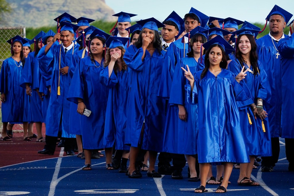 Waiʻanae High School seniors laugh and pose for friends and ʻohana in the stands for their commencement ceremony Friday, May 22, 2026, in Waiʻanae. (Kevin Fujii/Civil Beat/2026)